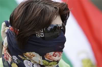 2nh2c5w 1 - A woman wears a mask during a protest in front of the White House